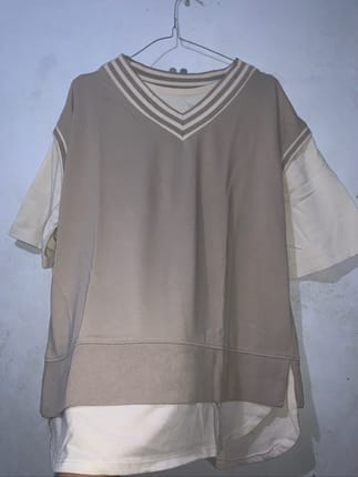 Pakaian bergaya layer ini memiliki detail kerah V bergaris y